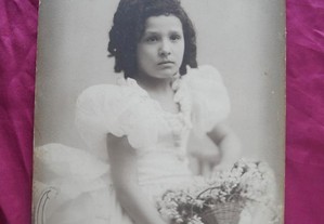 Foto antiga de menina com cesto de flores.