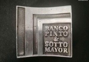 Pisa papéis em metal com publicidade do Banco Pinto & Sotto Mayor