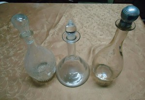 Três garrafas de vidro antigas trabalhadas