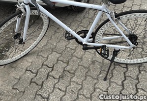 Bicicleta fixie em bom estado customizada, cor branca com uma jante espacial.